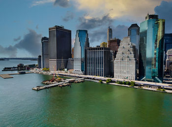 Modern buildings by sea against sky in city