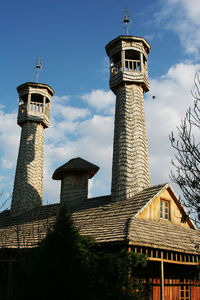 Low angle view of lighthouse against buildings