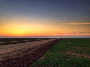 Scenic view of field against sky at sunset