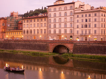 Bridge over river against buildings in city