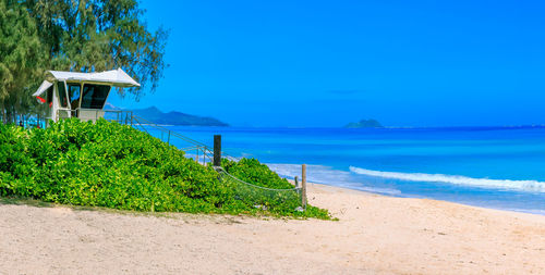 Scenic view of beach against clear blue sky