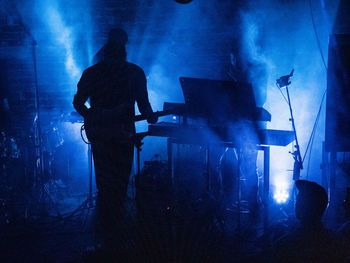 Silhouette people standing against illuminated light