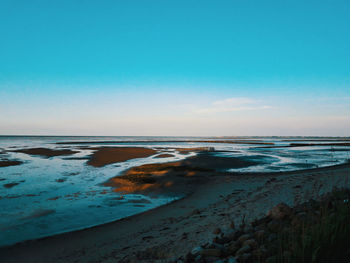 Scenic view of beach against blue sky