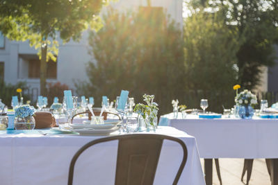 Chairs and tables at dining table against trees