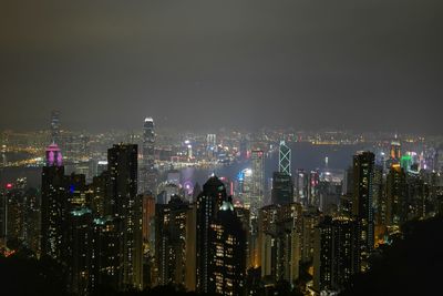 Illuminated cityscape against sky at night