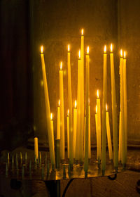 Row of illuminated candles in temple