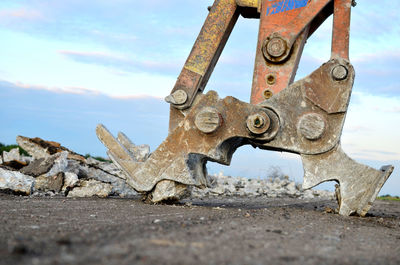 Close-up of rusty machine part against sky