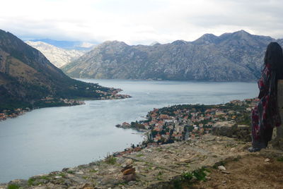 Scenic view of sea and mountains against cloudy sky