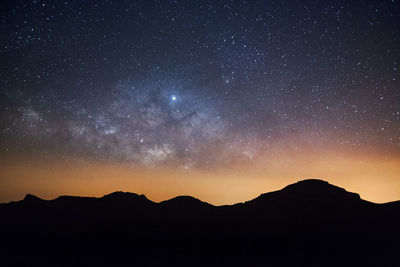 Scenic view of silhouette mountain against sky at night