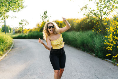 Full length of a young woman with umbrella on road