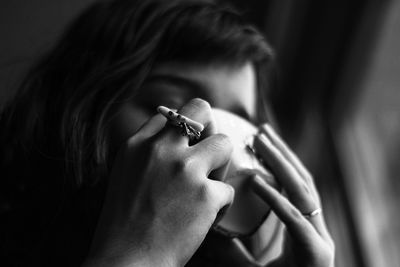 Close-up of woman drinking coffee at home