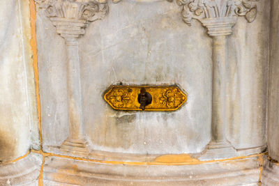 Close-up of buddha sculpture against old building