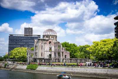 Buildings in city against cloudy sky