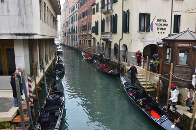 People in canal amidst buildings in city