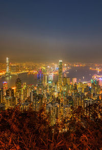 Illuminated buildings in city against sky at night