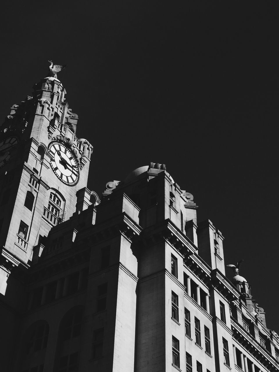 low angle view, architecture, built structure, building exterior, clock tower, tower, clock, tall - high, time, sky, tall, outdoors, spire, city life, high section, history, facade, gothic style, no people, town hall