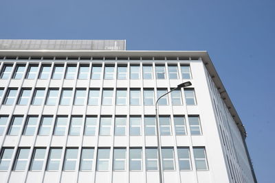 Low angle view of modern building against clear blue sky