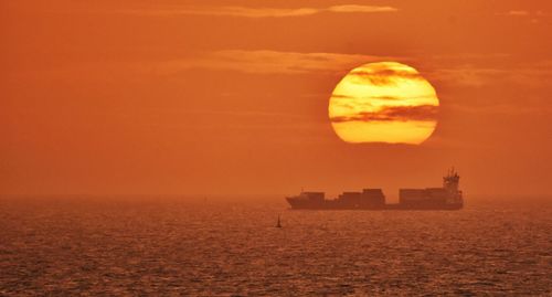 Scenic view of sea against orange sky