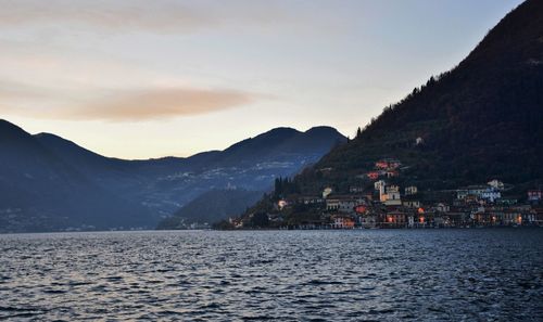 Scenic view of sea by town against sky