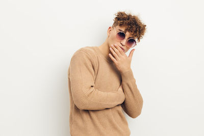 Young woman wearing sunglasses against white background