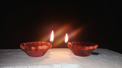 Close-up of illuminated candles on black background