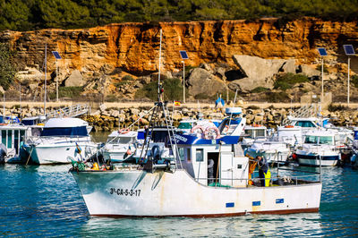 Sailboats moored on sea by harbor