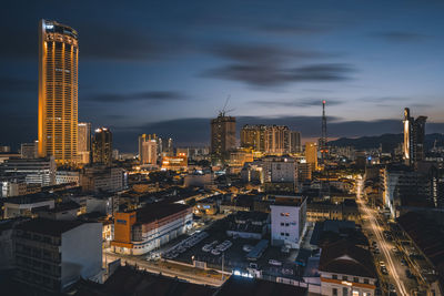 Illuminated buildings in city against sky at night