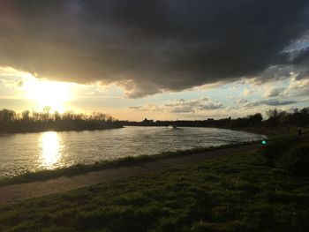 Scenic view of river against sky at sunset