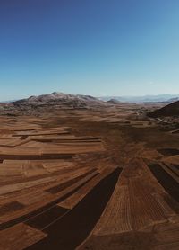 Scenic view of desert against clear blue sky