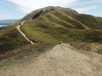 Pathway on a scenic view of mountains against sky at mount holbung in north sumatra