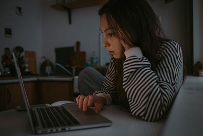 Young woman using laptop at home