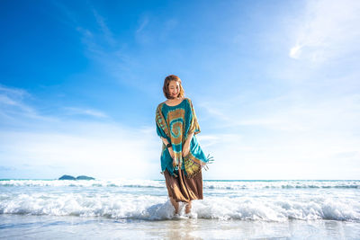 Man standing at beach against sky