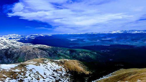 Scenic view of snowcapped mountains against blue sky