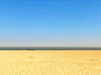 Scenic view of beach against clear blue sky