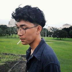 Portrait of young man wearing eyeglasses on field