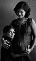 Portrait of a smiling boy standing next to mother