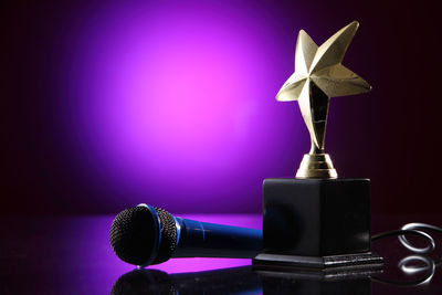 Close-up of microphone and trophy on table