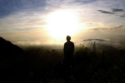 Rear view of silhouette man standing against sky during sunset