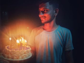 Mid adult man against illuminated fire