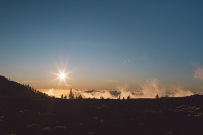 Scenic view of silhouette field against sky during sunset