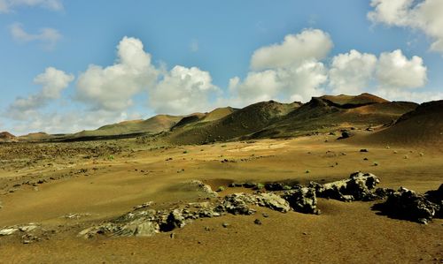 View of desert against cloudy sky