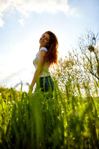 Young woman standing amidst plants