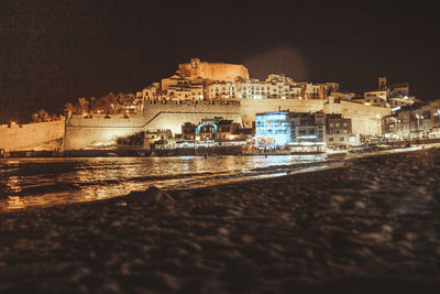 Reflection of illuminated buildings in sea at night