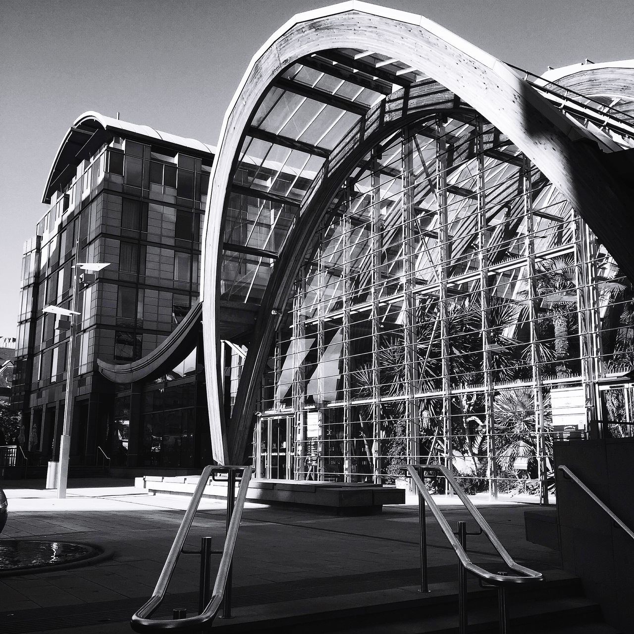 architecture, built structure, building exterior, clear sky, railing, sunlight, day, city, low angle view, outdoors, steps, building, metal, sky, arts culture and entertainment, incidental people, pattern, shadow, modern, glass - material