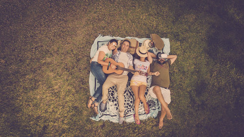 High angle view of friends lying down on field