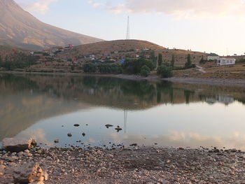 Scenic view of lake by buildings against sky