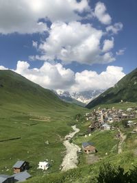 Scenic view of field and houses against sky