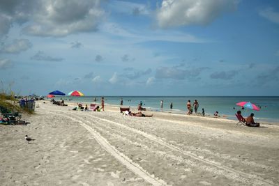 People at beach against sky