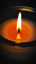 Close-up of lit candle in dark room