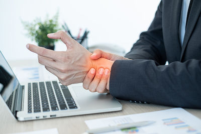 Midsection of man using laptop on table